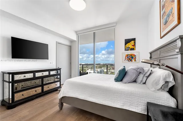 a bedroom with a bed and a flat screen tv