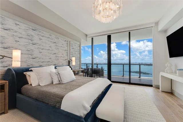 a bedroom with a large bed and a flat tv screen on the dresser