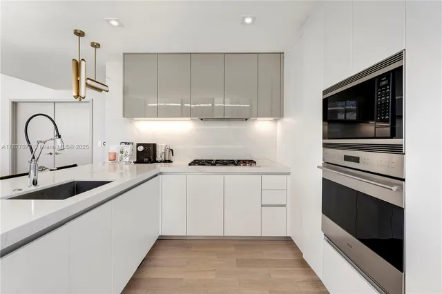a kitchen with granite countertop white cabinets and stainless steel appliances