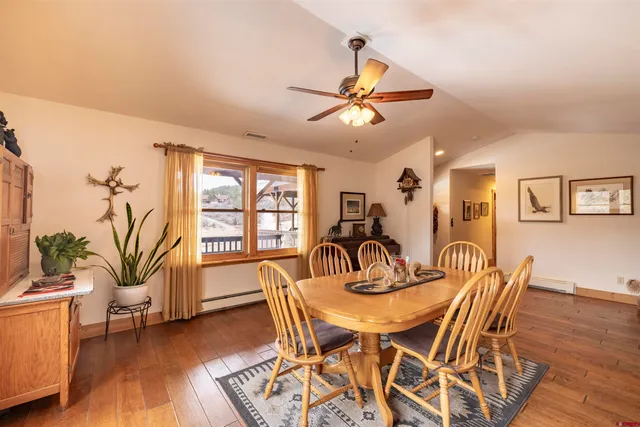 a dining room with furniture potted plants and wooden floor