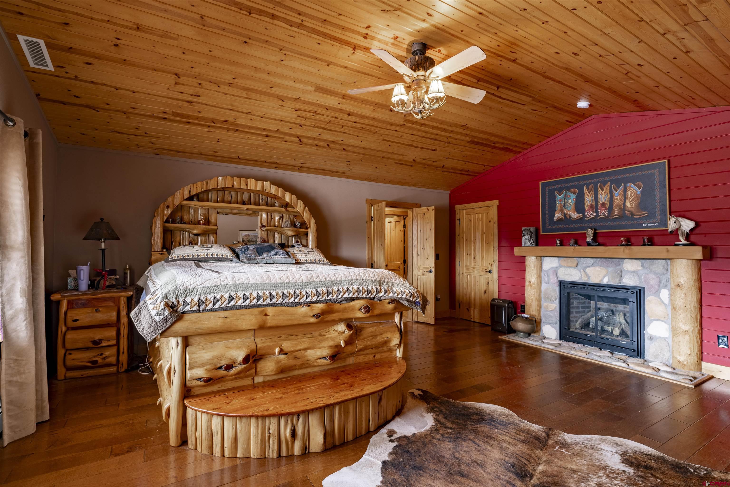 250 Sunset Lane Durango, CO 81301 - Photo 15 of 44 a bedroom with a bed and a fireplace