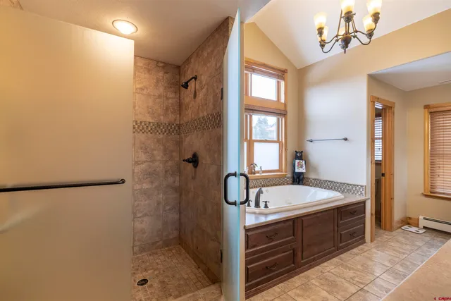 a bathroom with a tub sink shower and mirror
