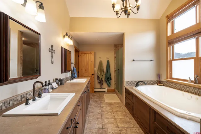 a spacious bathroom with a bathtub sink and mirror