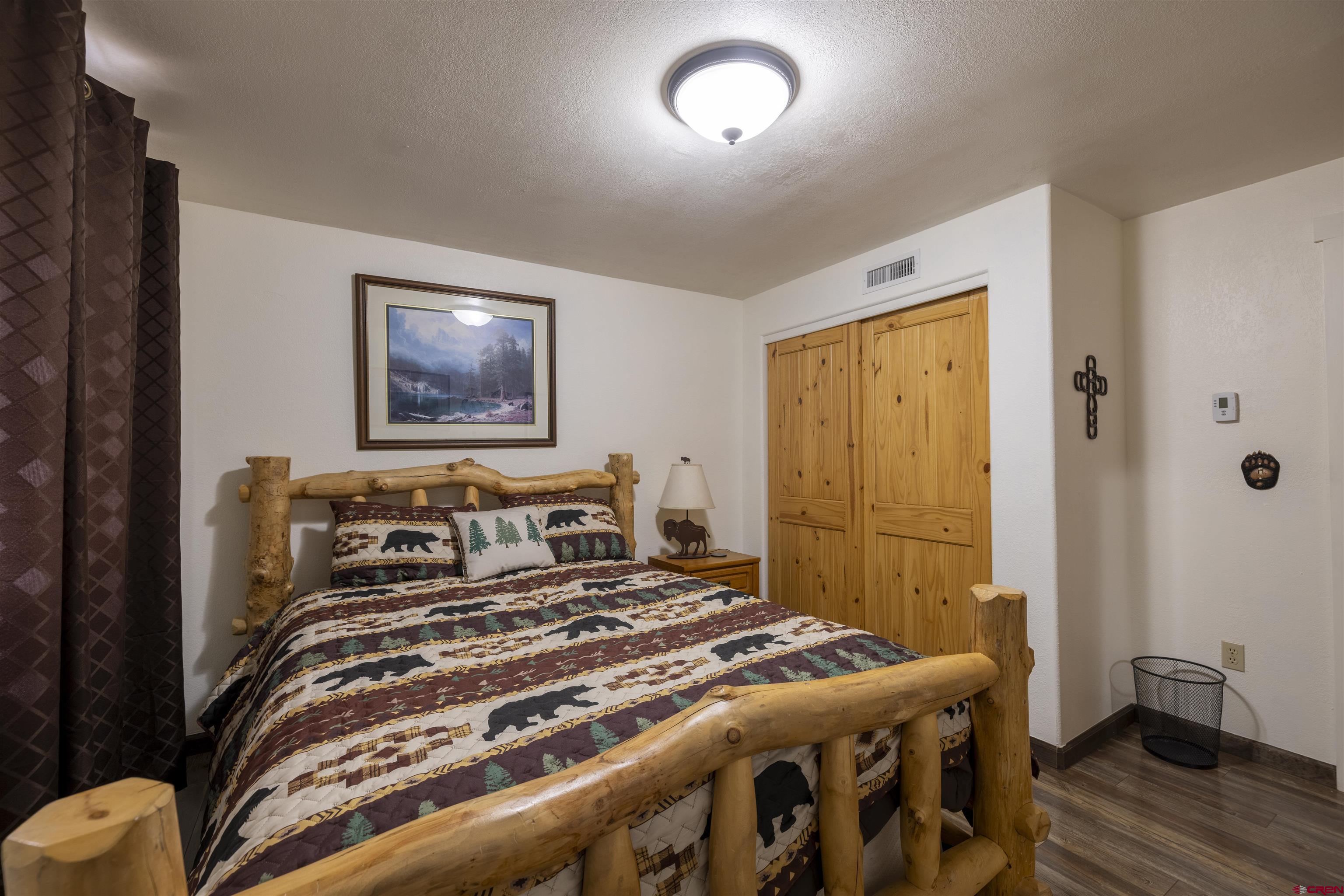 250 Sunset Lane Durango, CO 81301 - Photo 29 of 44 a bedroom with a bed and wooden floor