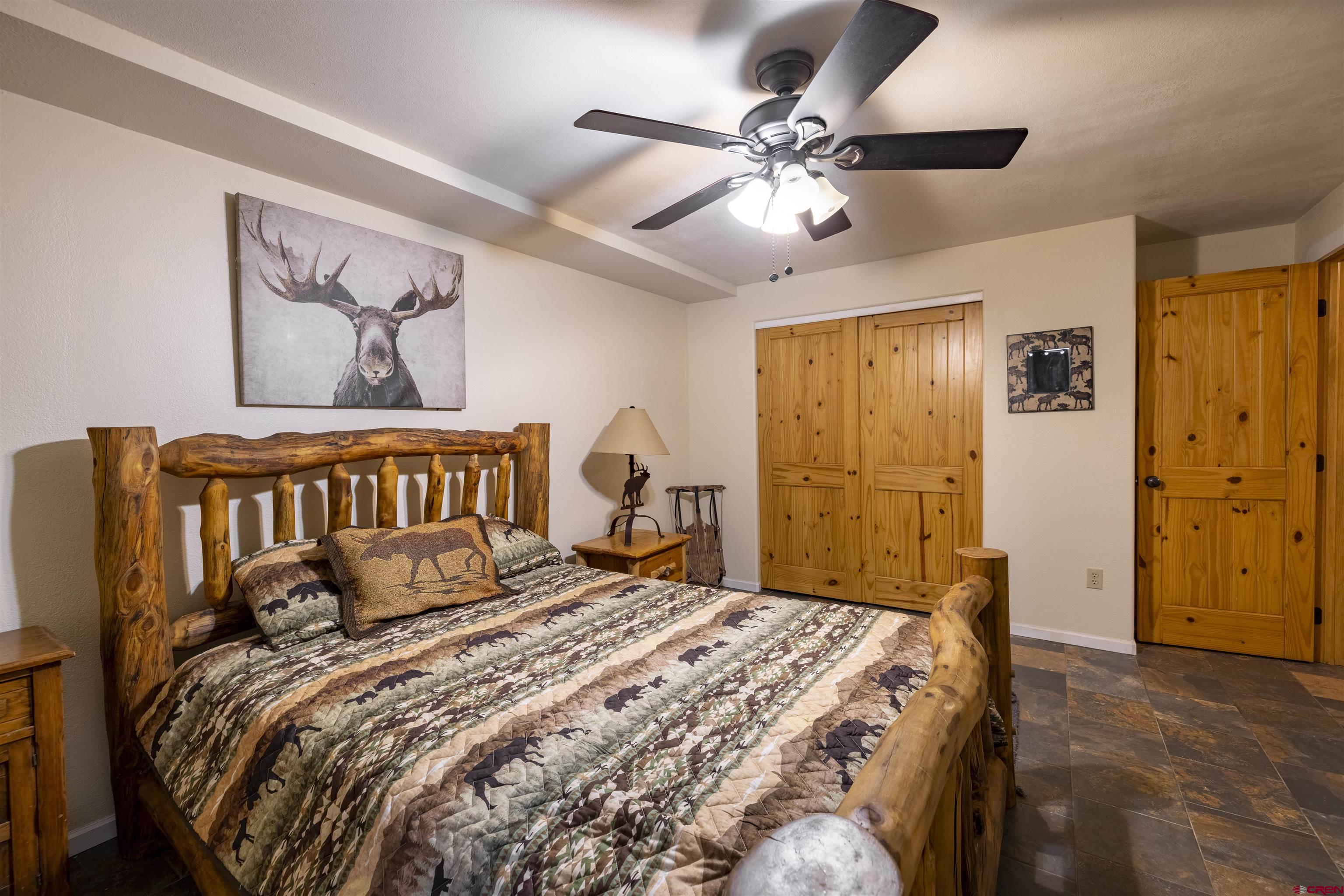 250 Sunset Lane Durango, CO 81301 - Photo 30 of 44 a bedroom with a large bed and a chandelier