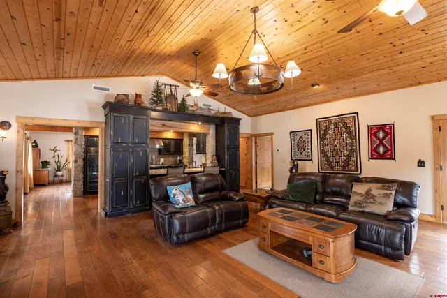 a living room with furniture a flat screen tv and a table