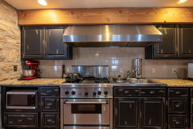 a kitchen with stainless steel appliances granite countertop a stove and a sink