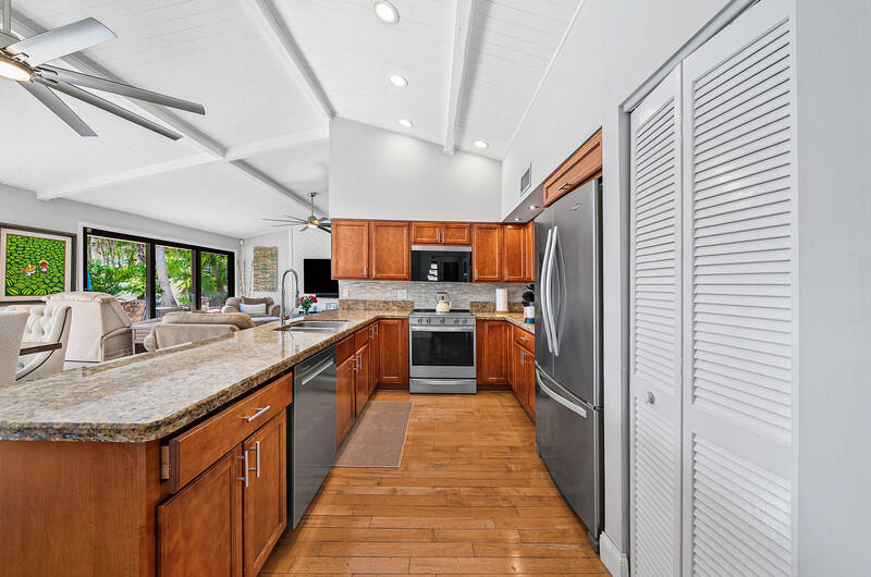 3026 Northeast 6th Drive Boca Raton, FL 33431 - Photo 21 of 49 a large kitchen with stainless steel appliances kitchen island granite countertop a large counter top stainless steel appliances and cabinets