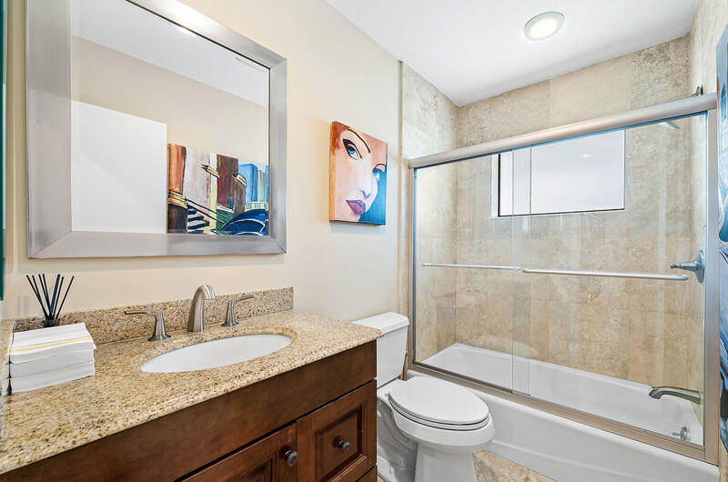 3026 Northeast 6th Drive Boca Raton, FL 33431 - Photo 36 of 49 a bathroom with a granite countertop sink a toilet and a bathtub