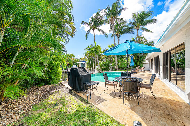 3026 Northeast 6th Drive Boca Raton, FL 33431 - Photo 40 of 49 a view of a patio with chairs and table under an umbrella