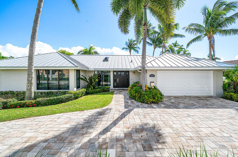 3026 Northeast 6th Drive Boca Raton, FL 33431 - Photo 4 of 49 a front view of a house with a yard and potted plants