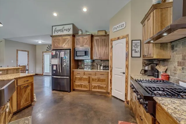 a kitchen with stainless steel appliances granite countertop a stove and a refrigerator