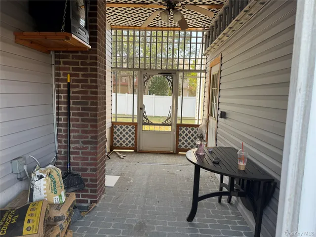 a view of a porch with furniture and floor to ceiling window