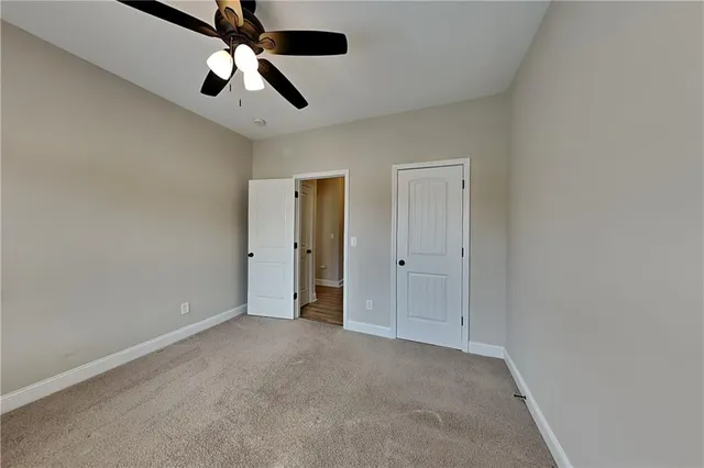 an empty room with chandelier fan