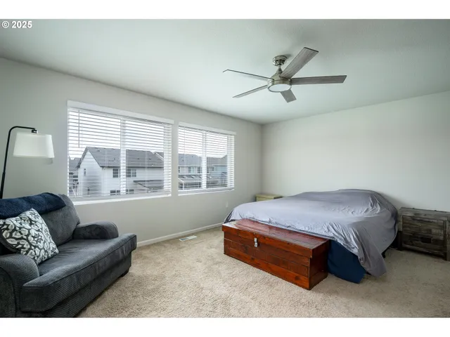 a bedroom with a bed and a large window