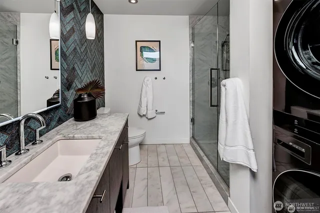 a bathroom with a granite countertop sink a toilet and a shower