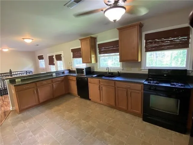 a kitchen with stainless steel appliances granite countertop a stove a sink and a microwave