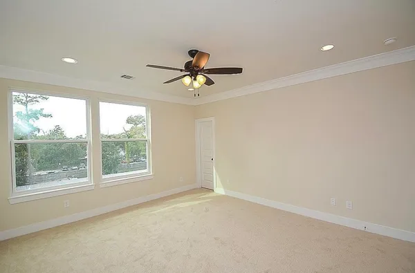 an empty room with a window and a ceiling fan