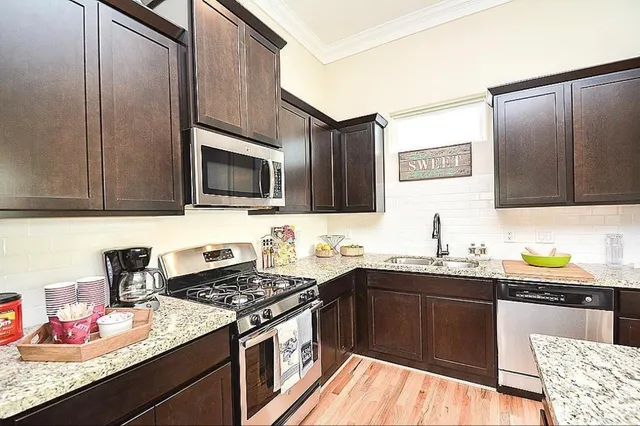 a kitchen with stainless steel appliances a sink stove and cabinets