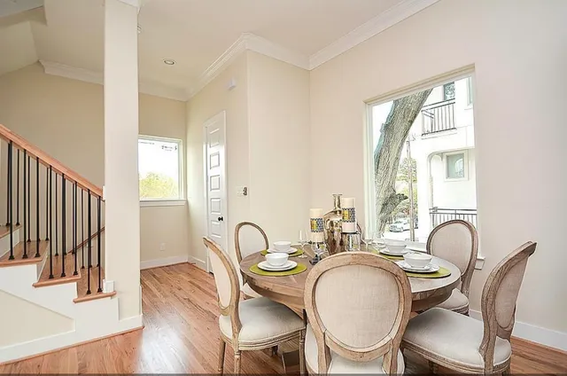 a dining room with furniture a window and wooden floor
