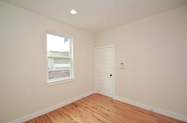 an empty room with wooden floor and window