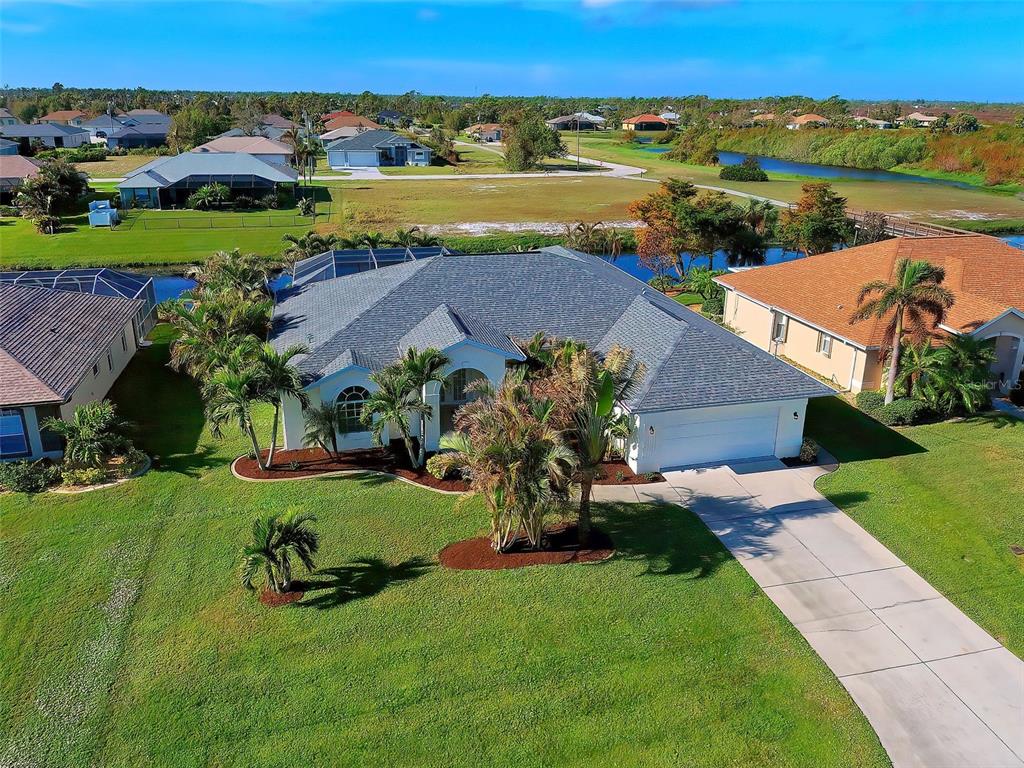 an aerial view of a house with a garden and lake view