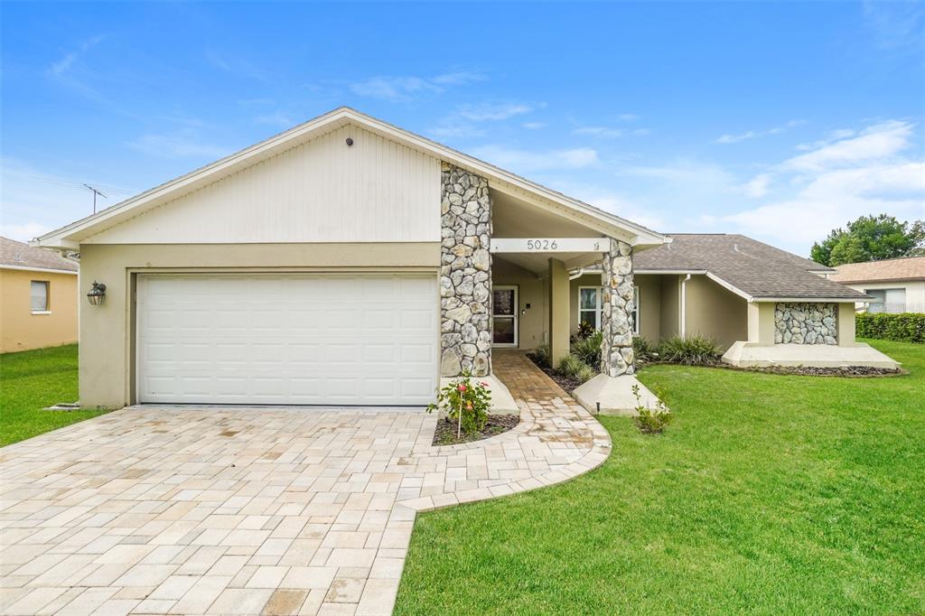 5026 Plumosa Street Spring Hill, FL 34607 - Photo 1 of 1 a front view of a house with a yard and garage