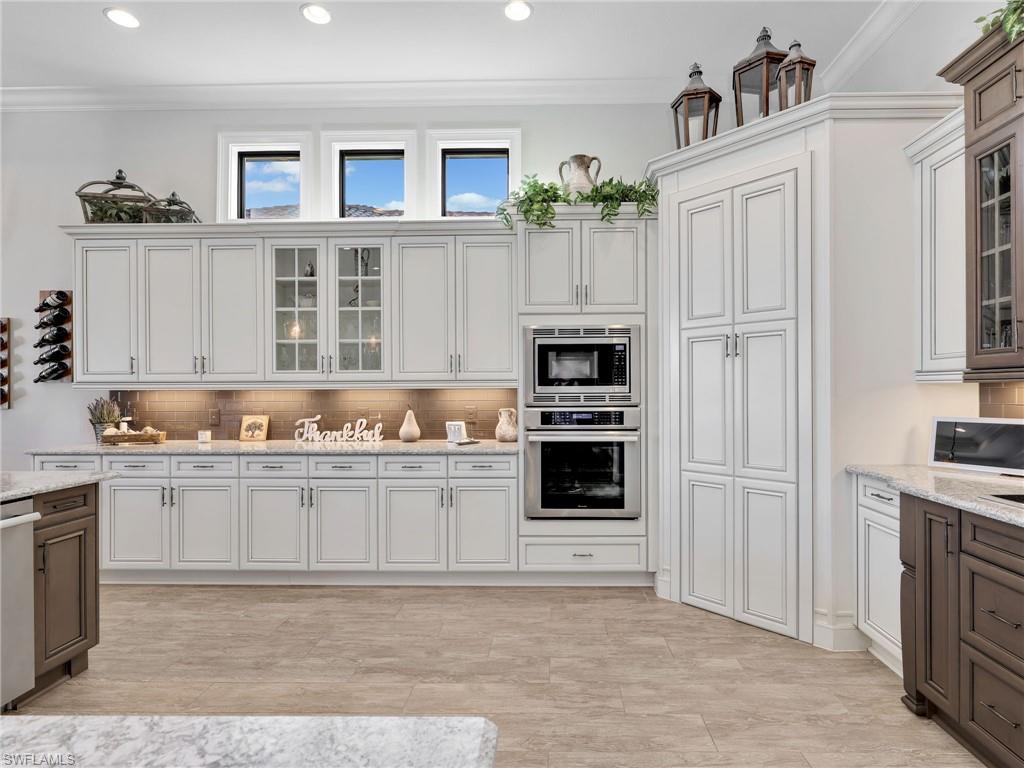 12757 Dundee Lane Naples, FL 34120 - Photo 14 of 48 a kitchen with granite countertop a stove a sink and a refrigerator