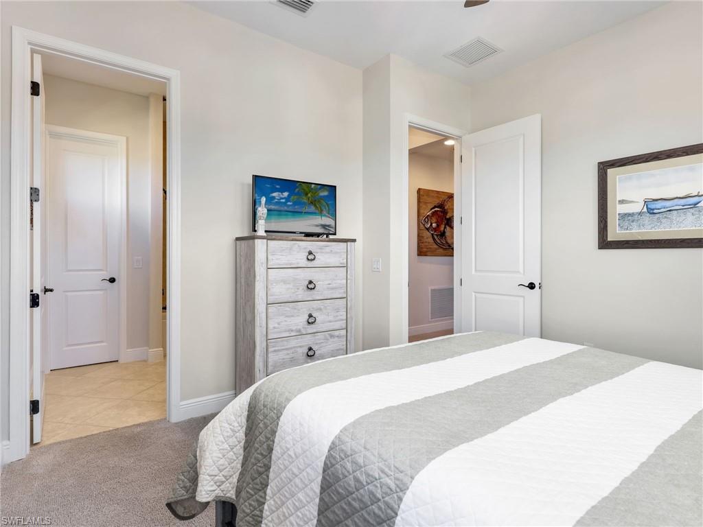 12757 Dundee Lane Naples, FL 34120 - Photo 22 of 48 a bedroom with a bed and a television