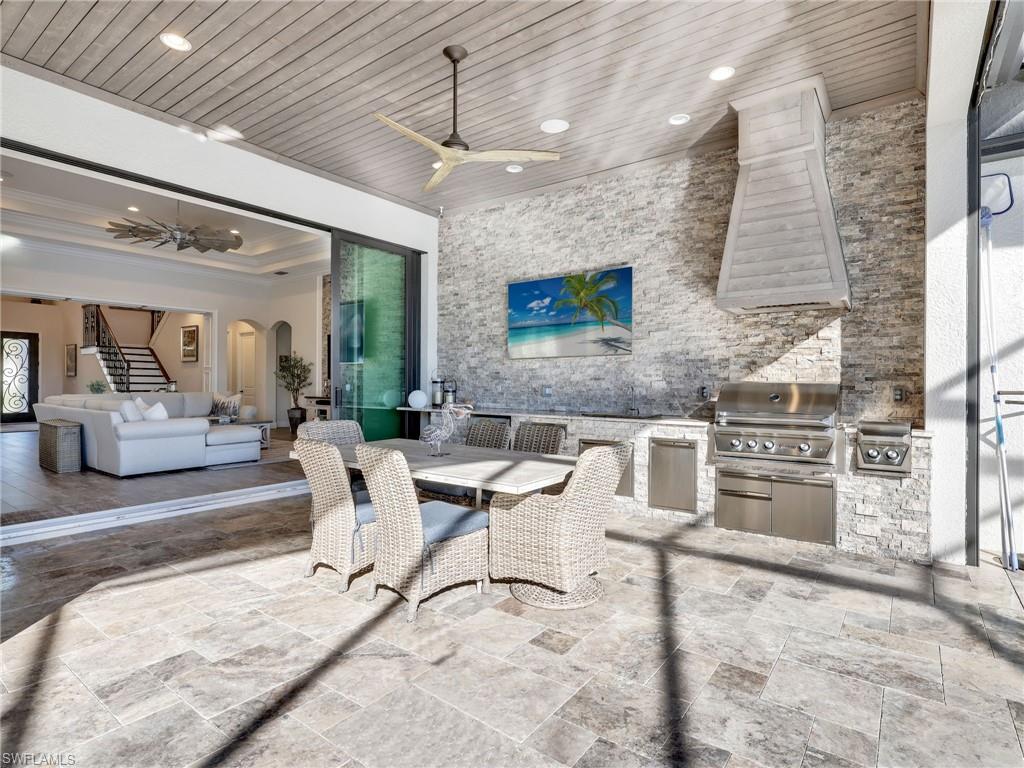 12757 Dundee Lane Naples, FL 34120 - Photo 35 of 48 a living room with stainless steel appliances kitchen island granite countertop furniture and a fireplace