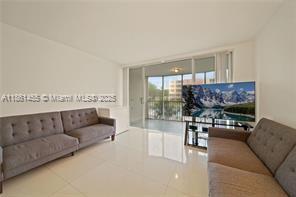 1710 Northeast 191st Street, Unit 2053 Miami, FL 33179 - Photo 2 of 9 a living room with furniture and a flat screen tv