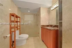 a bathroom with a granite countertop sink toilet and shower
