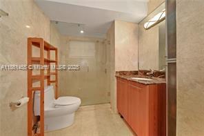 1710 Northeast 191st Street, Unit 2053 Miami, FL 33179 - Photo 6 of 9 a bathroom with a granite countertop sink toilet and shower