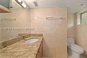 a bathroom with a sink toilet vanity and shower