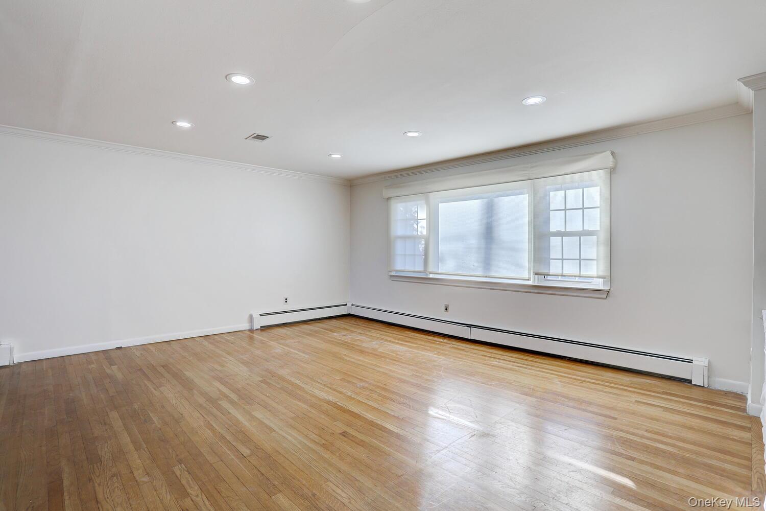 12 Van Gogh Lane Airmont, NY 10901 - Photo 2 of 21 an empty room with wooden floor and windows