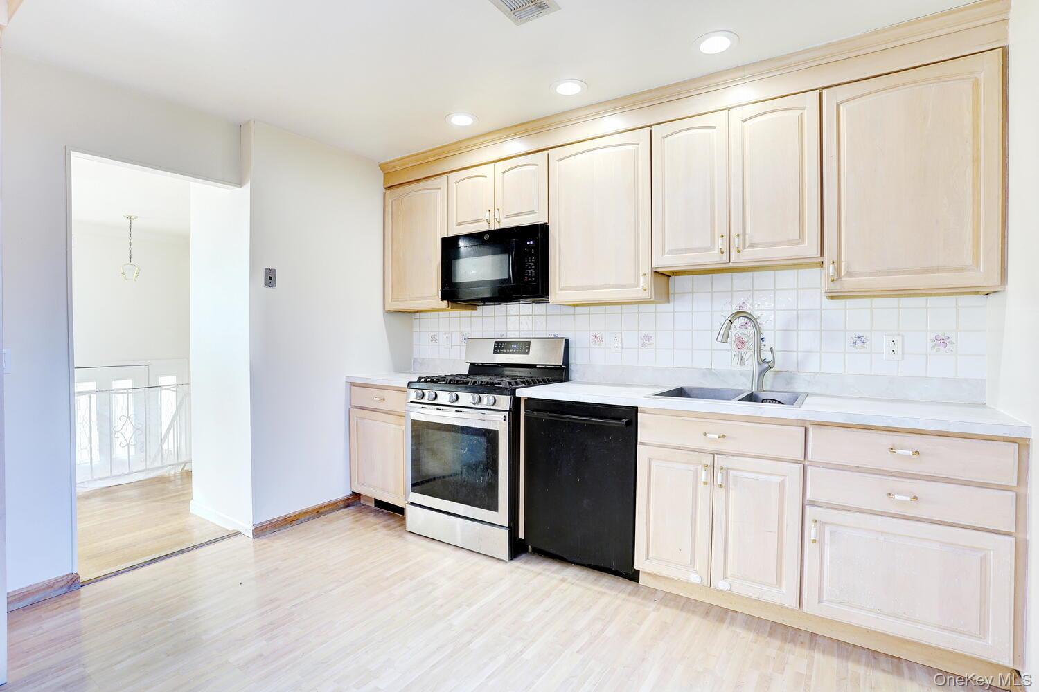 12 Van Gogh Lane Airmont, NY 10901 - Photo 7 of 21 a kitchen with granite countertop a stove a sink and a microwave