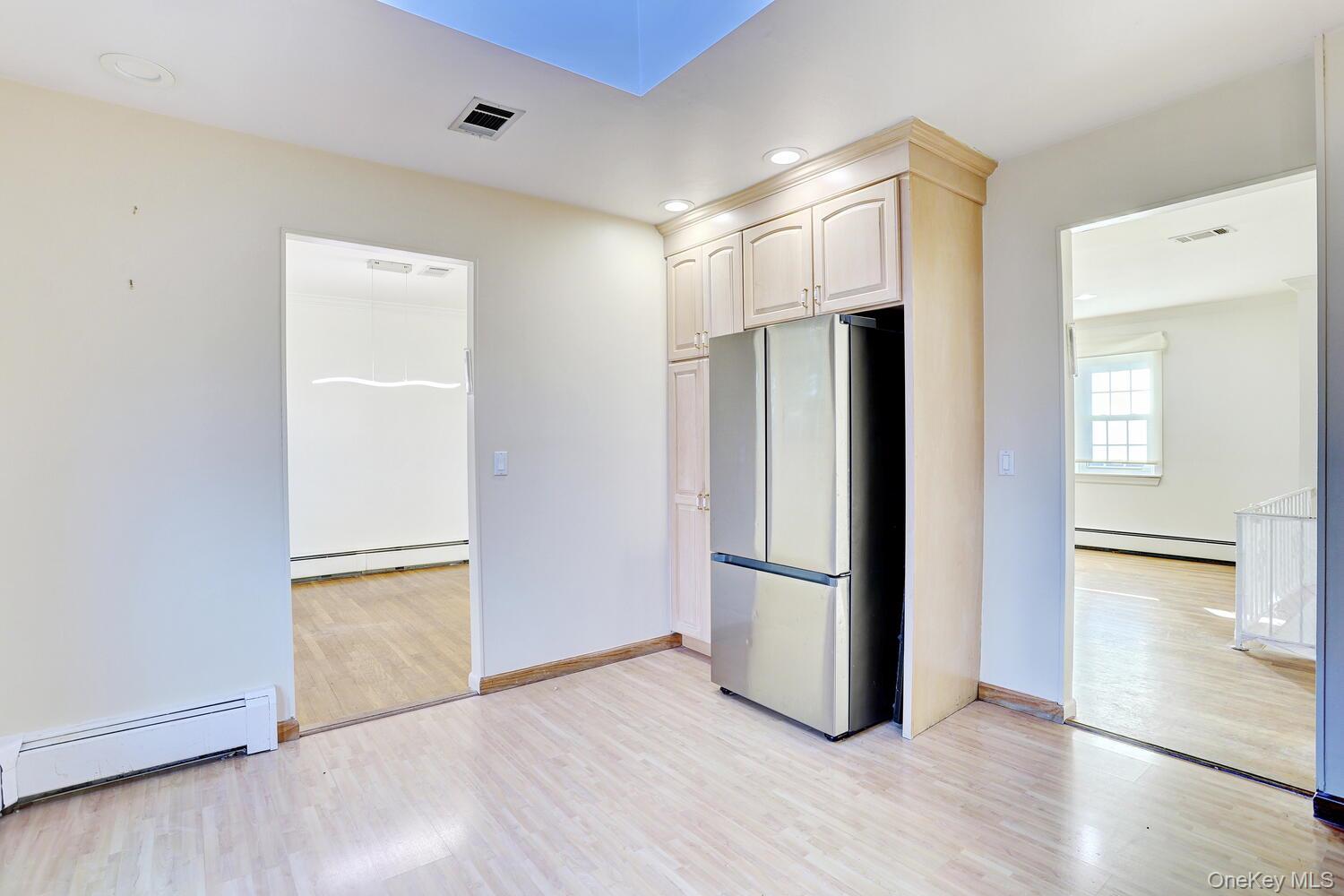 12 Van Gogh Lane Airmont, NY 10901 - Photo 8 of 21 an empty room with wooden floor and a kitchen