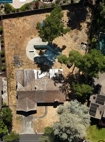 an aerial view of a house with a yard and large trees