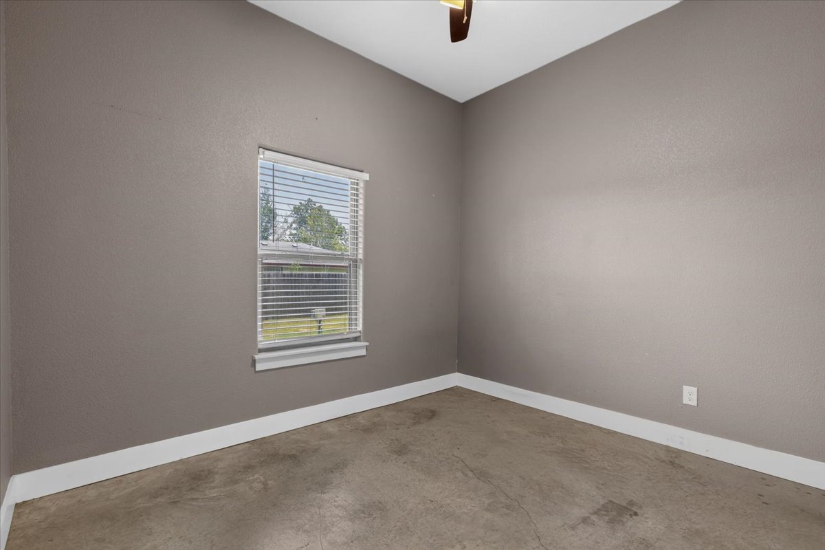 145 Cardinal Loop Paige, TX 78659 - Photo 30 of 40 A well-lit room with concrete flooring, perfect for a versatile living space.