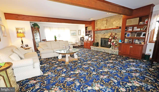 a living room with furniture a rug and a floor to ceiling window