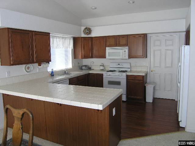 15510 Quicksilver Drive Reno, NV 89511 - Photo 2 of 3 a kitchen with stainless steel appliances granite countertop a sink a stove top oven a counter space and cabinets
