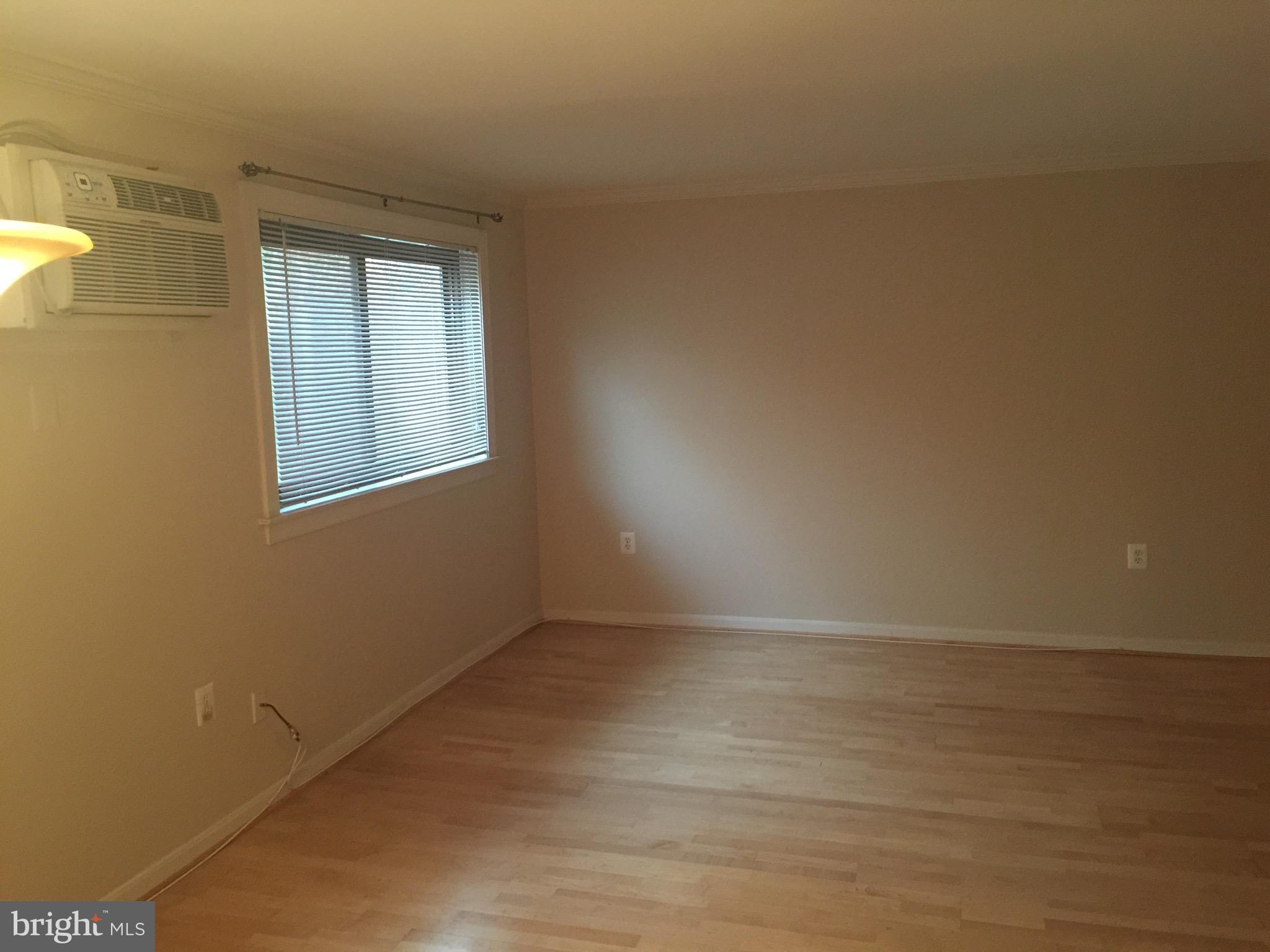 3107 Naylor Road Southeast, Unit 204 Washington, DC 20020 - Photo 3 of 17 a view of an empty room with wooden floor and a window