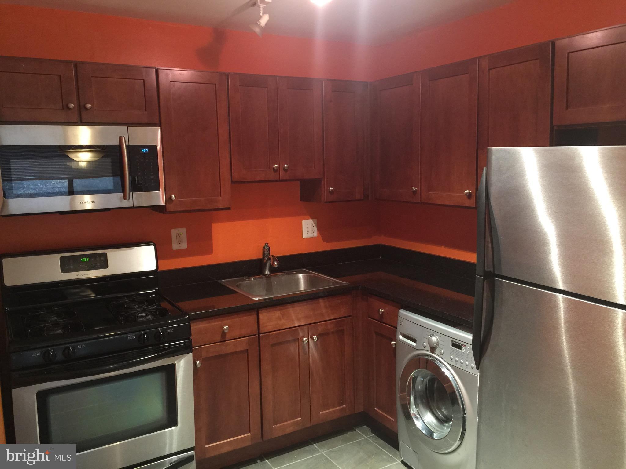 3107 Naylor Road Southeast, Unit 204 Washington, DC 20020 - Photo 5 of 17 a kitchen with a sink and a refrigerator
