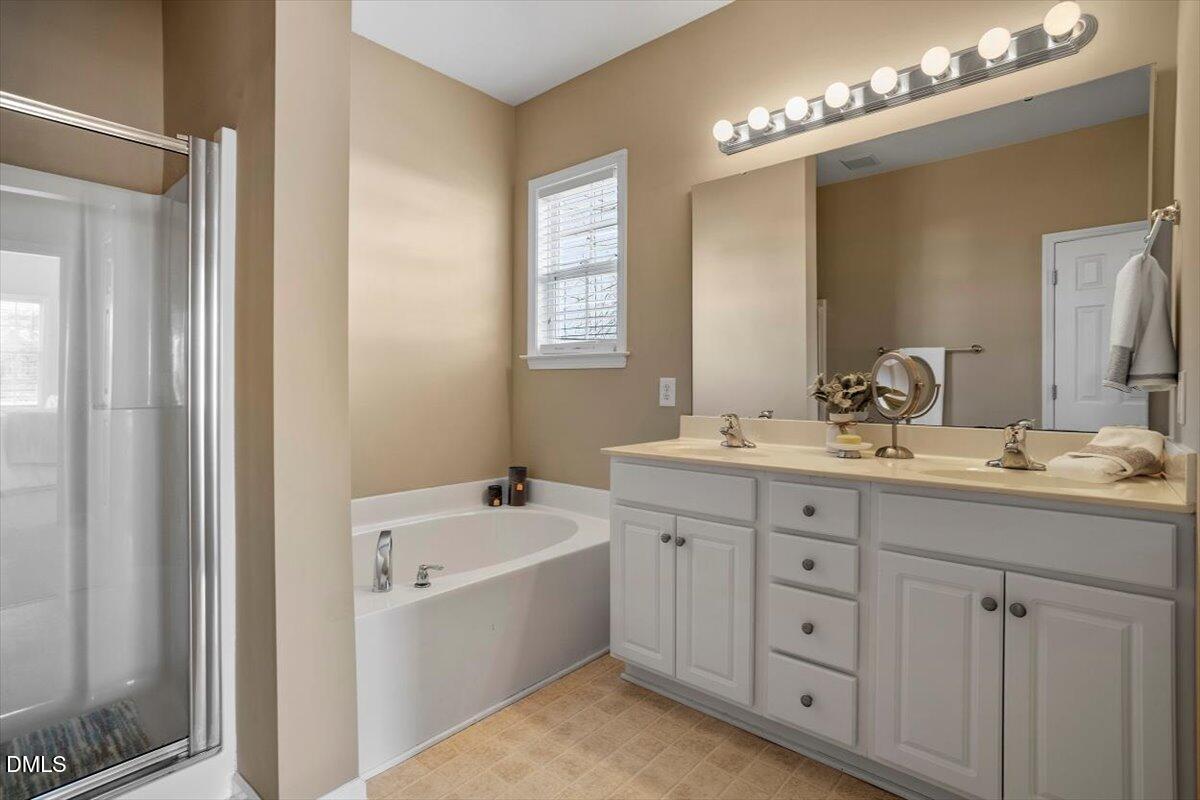 119 Victory Circle Willow Spring, NC 27592 - Photo 12 of 33 a bathroom with double vanity sink a vanity and a large mirror