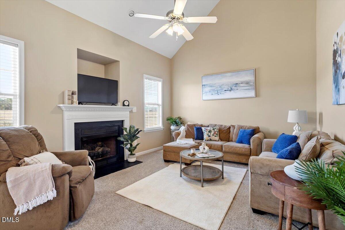 119 Victory Circle Willow Spring, NC 27592 - Photo 15 of 33 a living room with furniture a fireplace and a flat screen tv