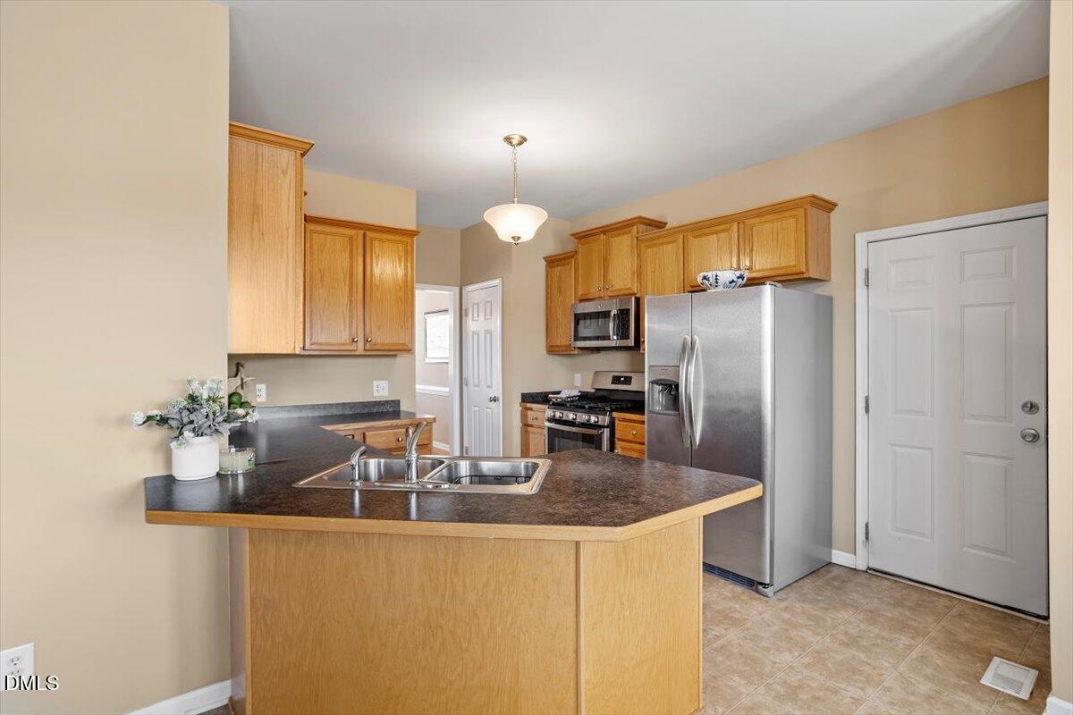 119 Victory Circle Willow Spring, NC 27592 - Photo 19 of 33 a kitchen with granite countertop a sink cabinets and stainless steel appliances