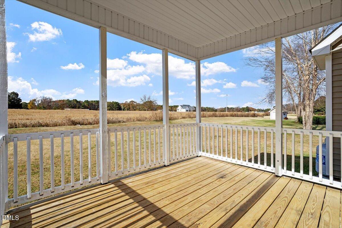 119 Victory Circle Willow Spring, NC 27592 - Photo 31 of 33 a view of a balcony with wooden floor next to a lake