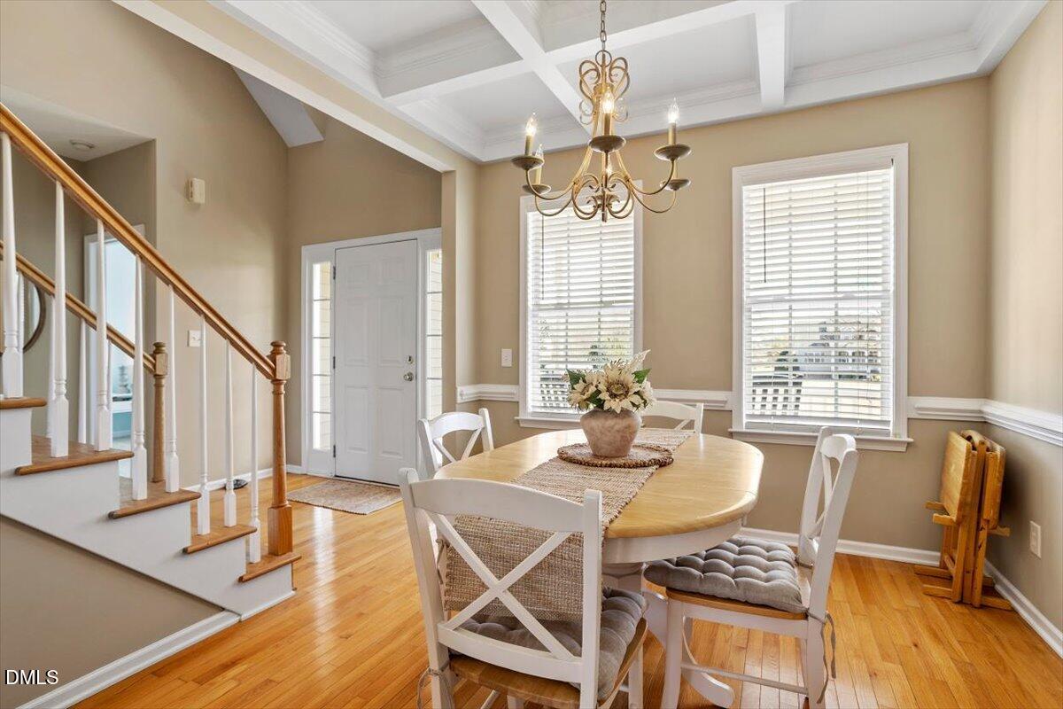 119 Victory Circle Willow Spring, NC 27592 - Photo 8 of 33 a dining room with wooden floor a chandelier a wooden table and chairs