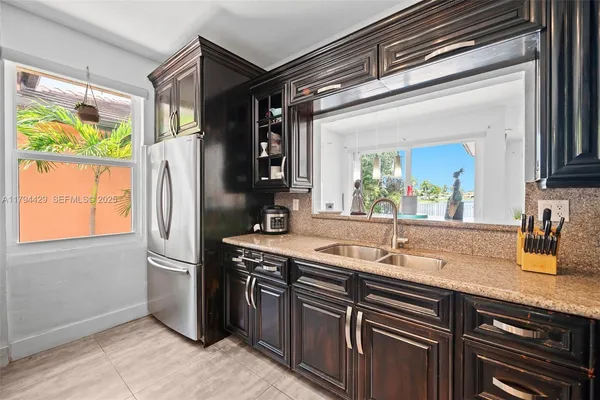 a kitchen with stainless steel appliances granite countertop a refrigerator and a sink