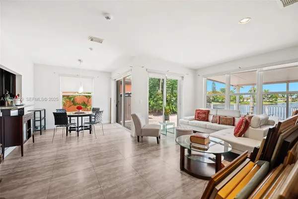 a living room with furniture flat screen tv and a large window